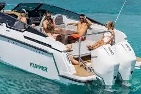 Group of four people relaxing on a Flipper boat in clear blue water, enjoying a sunny day.